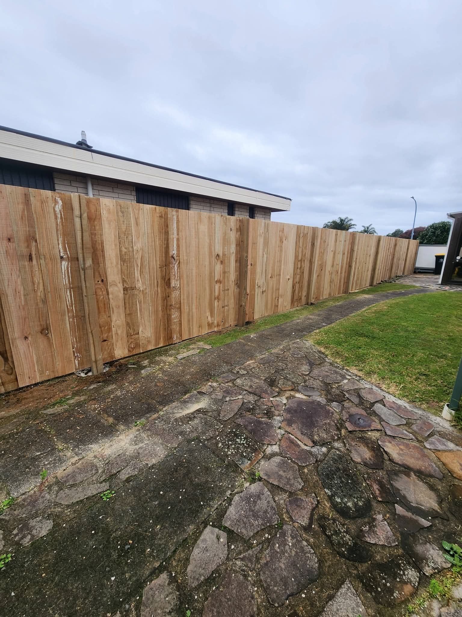 Long timber paling fence along side of property